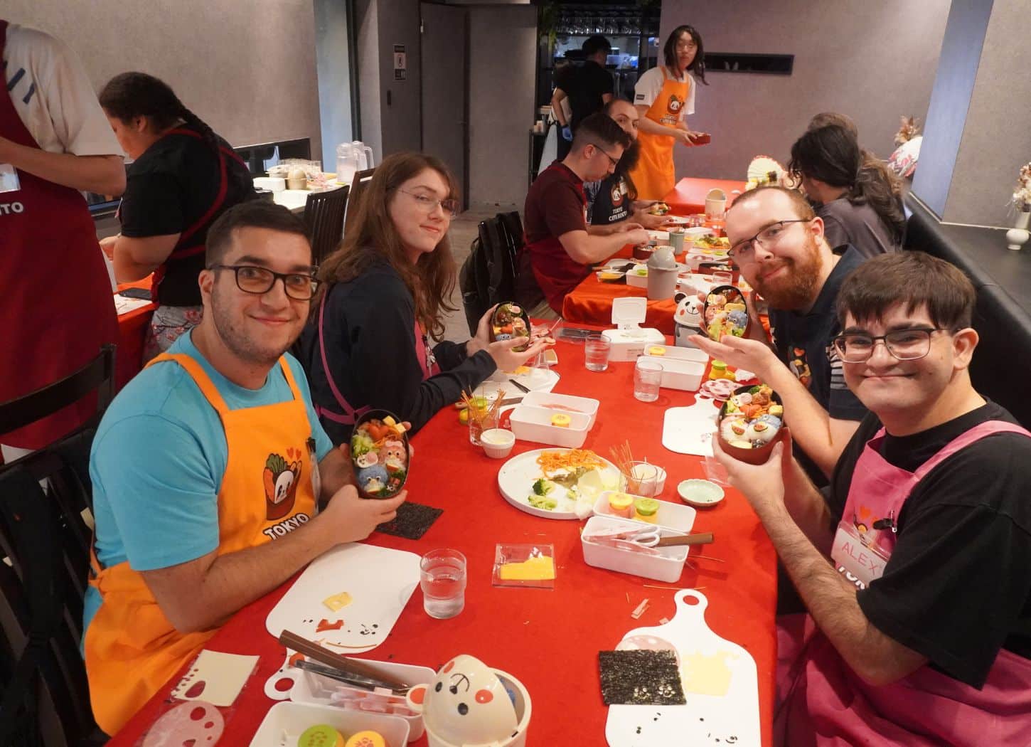 Guests at a long workshop table showing their finished character bento