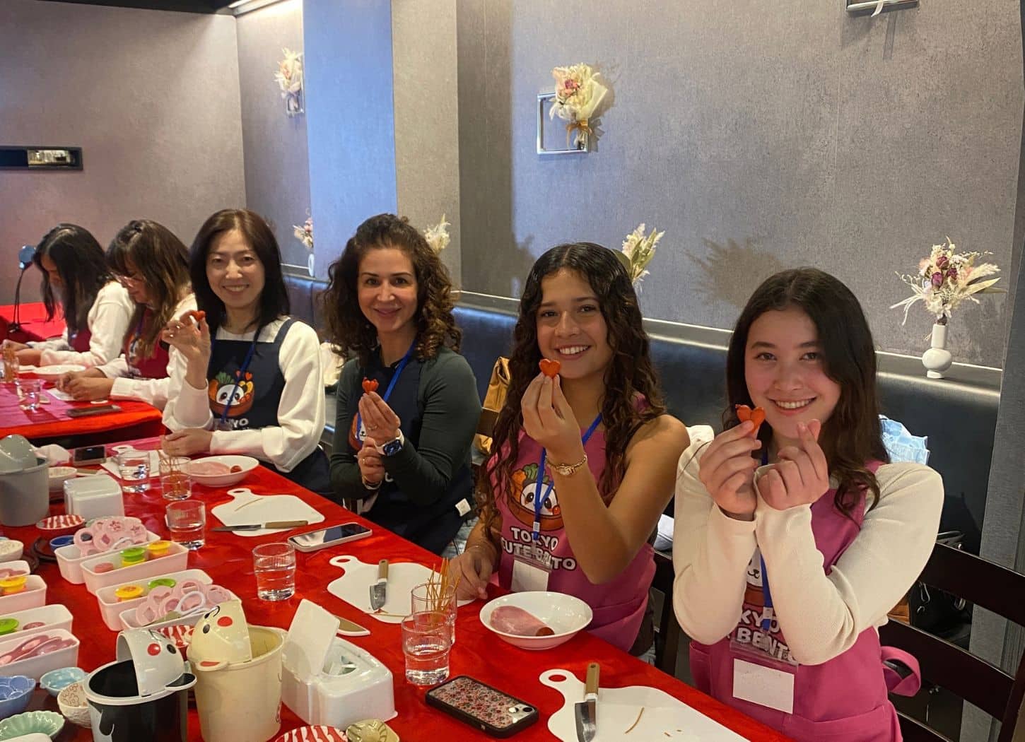 Group of guests holding up heart-shaped decorations at a group character bento workshop in Tokyo