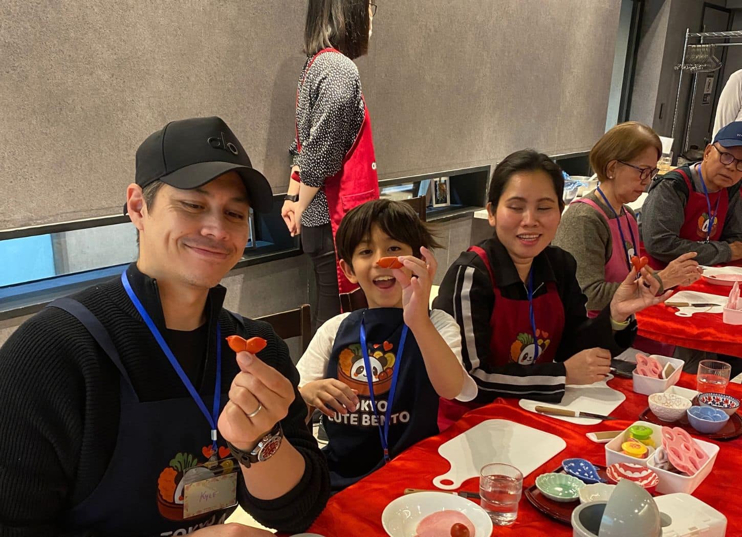 Child and parents holding up heart-shaped cutouts during the bento workshop